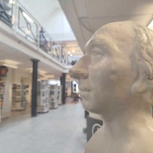 Gipsbuste af H. C. Andersen kigger ud over reolerne på Brønderslev Bibliotek.